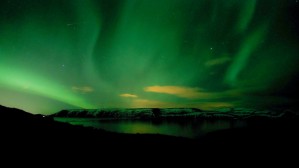 green northern lights on lake